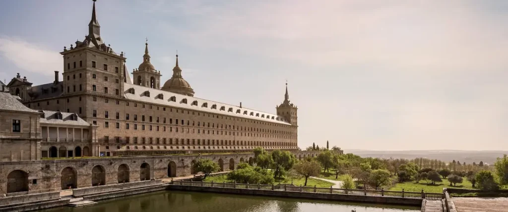 Vista panorámica del Monasterio de El Escorial y sus jardines geométricos, un referente del paisajismo histórico y el diseño exterior herreriano.