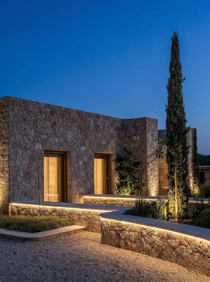 Una proyección de luz rasante vertical resalta los relieves y huecos de la mampostería, otorgando una tridimensionalidad que no se percibe durante el día