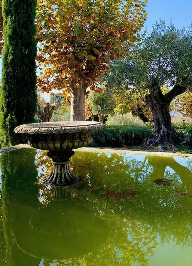 fuente clásica de agua integrada en paisaje castellano