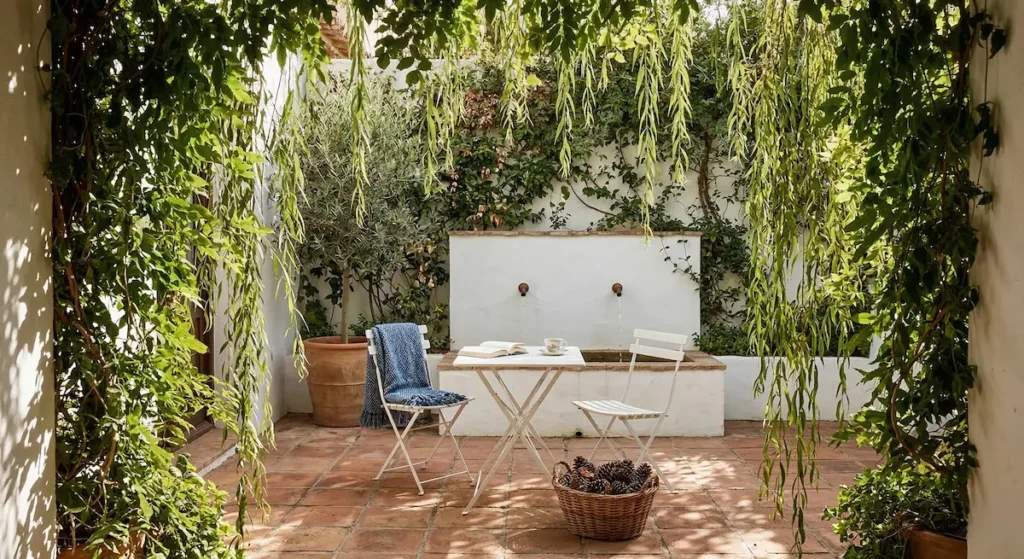 una "cortina" con ramas colgantes y enredaderas nos permite asomarnos al jardín desde la penumbra de un refugio íntimo.