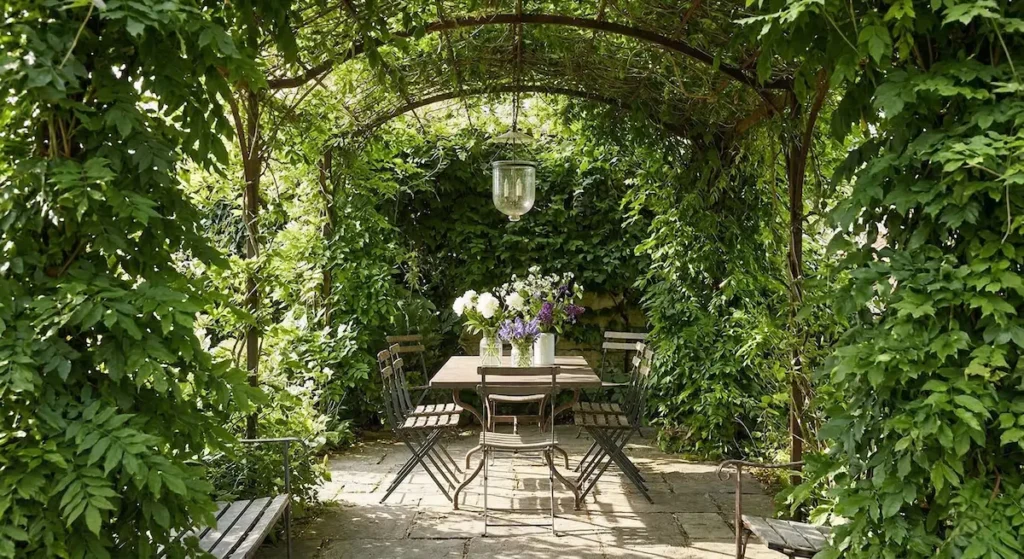 Una pérgola cubierta por densas plantas trepadoras es mucho más que una estructura; es un regulador natural de la temperatura y un refugio contra la intensidad del día.