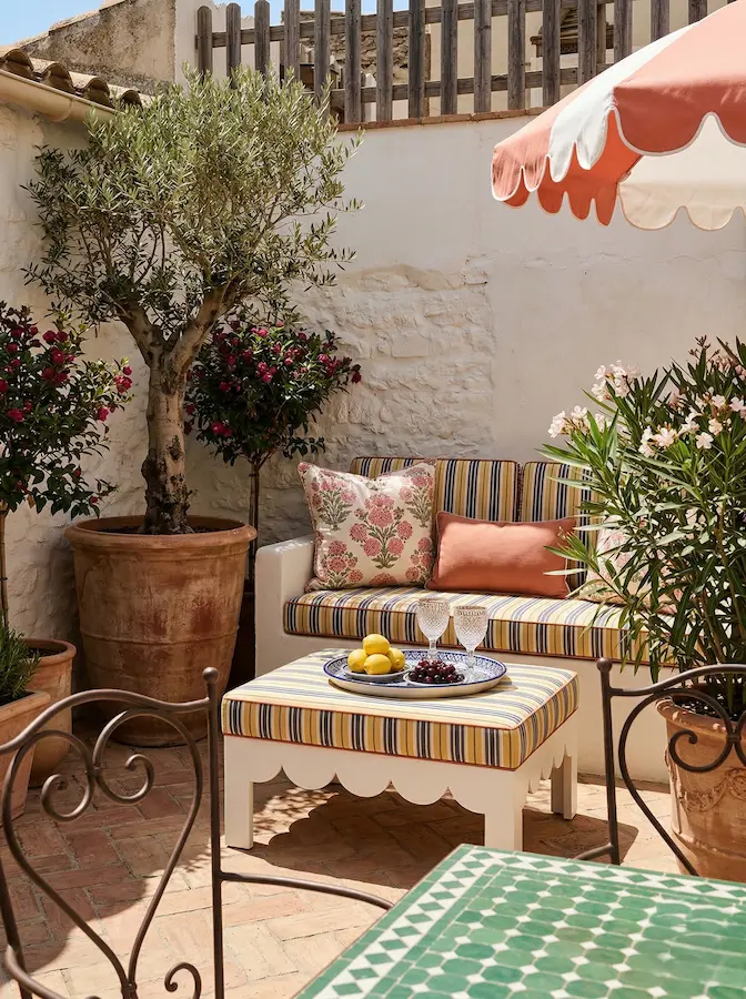 patio encalado con sofá y mesa acogedora vegetación mediteránea 